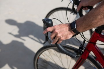 Obraz na płótnie Canvas Close-up of mans hand wearing smartwatch while riding bicycle