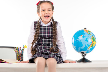 Happy schoolgirl sitting  with globe