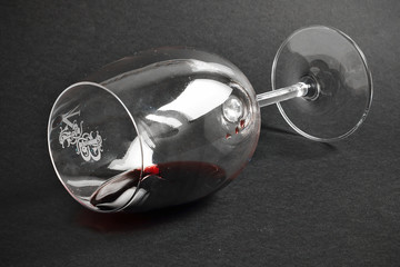 Copa de vino tinto tumbada sobre fondo negro