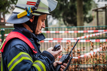 Fototapeta premium HDR - Einsatzleiter der Feuerwehr im Einsatz mit Funkgerät Walkie Talkie