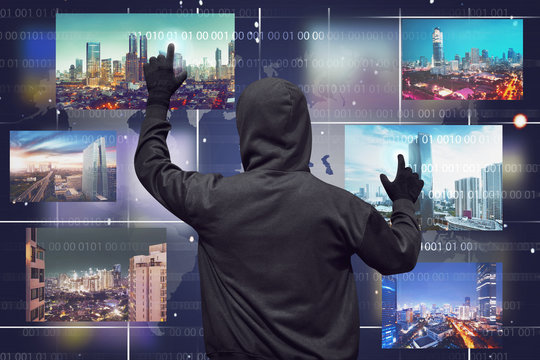 Back view of a hacker man touching virtual monitor