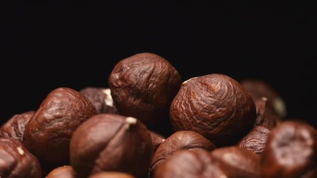 SLOW MOTION: Macro shot of falling of hazelnutes on a heap