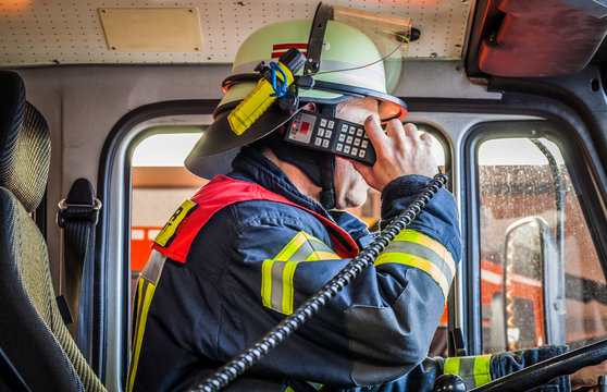 HDR - Feuerwehrmann im Einsatzfahrzeug im Einsatz mit Funkgerät