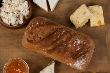 Variety of cheese with bread and sauce on chopping board
