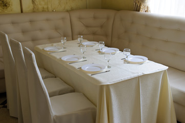 table set service with silverware and glass stemware at restaurant before party
