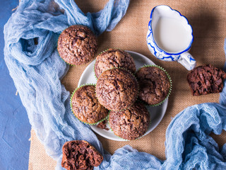 Chocolate banana muffins with sugar topping on dark blue background. Home made single portion snack. Winter baked dessert