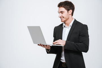 Handsome young caucasian businessman holding laptop