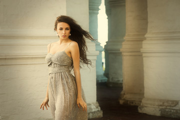 Young beautiful innocent woman with flying curly hair outdoor