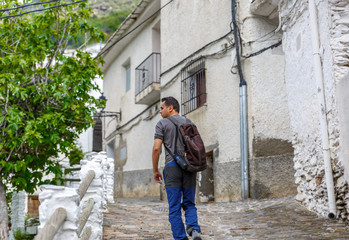 Obraz na płótnie Canvas A tourist walks along a rustic street of a village