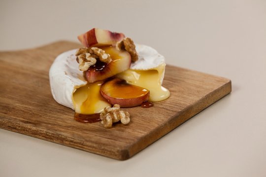 Cheese topped with walnut, fruits and sauce