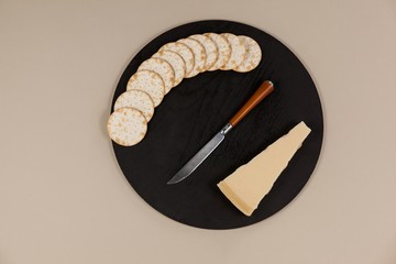 Slice of cheese with crispy biscuits and knife