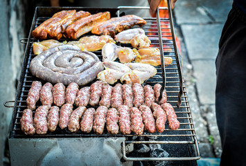 Mixed variety of Meat on barbecue grill with coal.