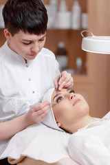 Obraz na płótnie Canvas Professional stylist making eyelash extension for women
