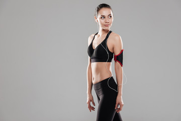 Obraz premium Pretty young fitness lady standing over grey background