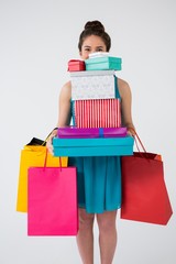 Woman carrying stack of gift boxes and shopping bags