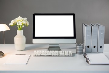 Desktop pc with flower vase and files 