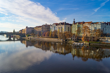 Coastline in Prague. Vltava river mirror reflaction in warm autumn light cloudy morning