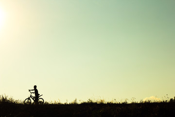 Fototapeta na wymiar Silhouette of children cyclist riding Movement on the background