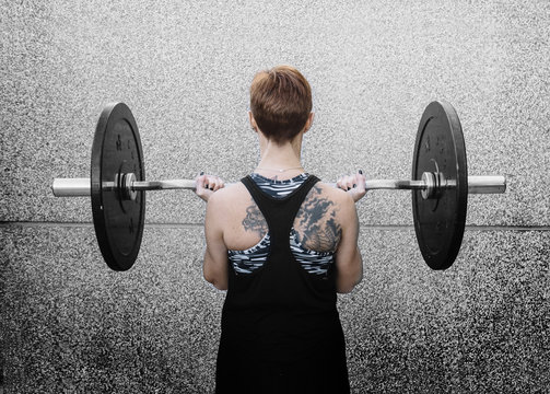 Woman working out with weights in the gym