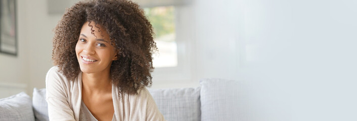 Attractive mixed race woman sitting in sofa