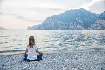 Fototapeta premium Woman meditating at the lake