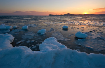 Sunset on the ice, winter coast