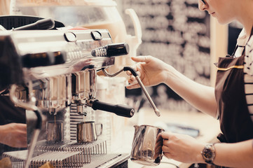 Barista preparing coffee in a coffee shop. Professional coffee making, service and catering concept