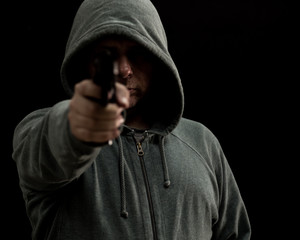 Obraz na płótnie Canvas Thug in hoodie points gun