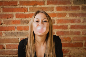 Funny girl making a pomp with a bubble gum
