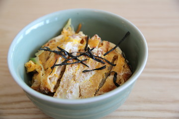 Japanese deep fried pork with egg on rice , Katsudon on wood bac