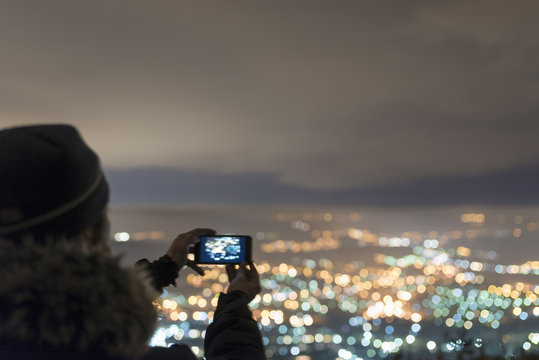 Watching the city from the mountain at night