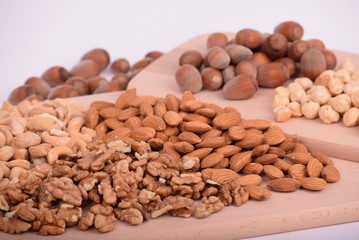 Various nuts served on a wooden board close-up