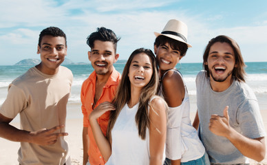 5 lachende Jugendliche am Strand