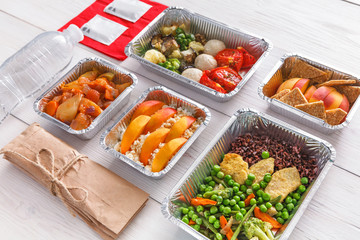 Healthy food take away in boxes, top view at wood