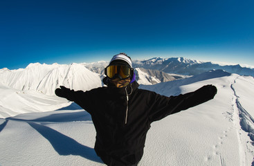 Fototapeta na wymiar A man in a good mood standing on snowy mountain