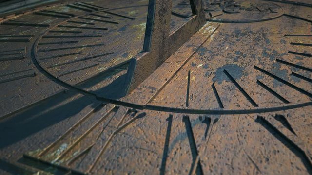 A 4K macro closeup time-lapse of a camera panning across a metal sundial with time passing over a day