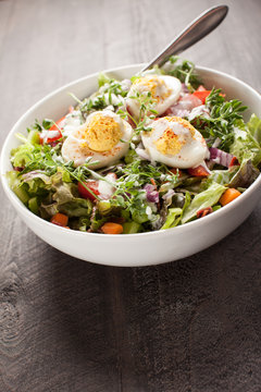 Angled Shot Of Large White Bowl Of Deviled Egg Salad On Dark Wooden Background