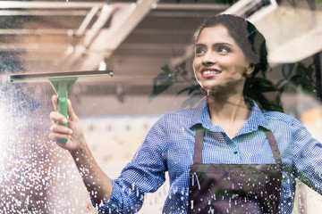 Indian employee cleaning windows