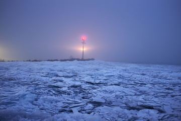 Ice cracks on the surface of a lake background lighthouse