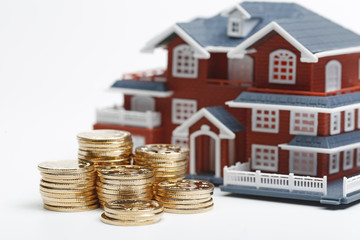 RMB coins stacked in front of the housing model (house prices, house buying, real estate, mortgage concept)