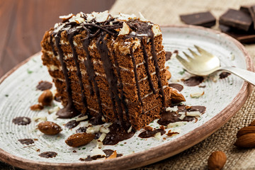 Tasty piece of chocolate Spartak cake on a rustic plate. Traditional delicious dessert on a table. Close-up shot.
