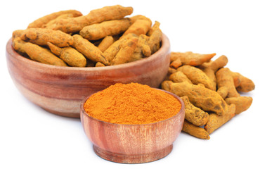 Whole and ground turmeric in bowl