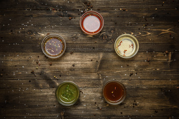 Sauces in glass bowls on wooden dark background