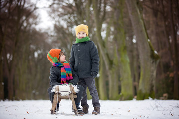 Fototapeta na wymiar Two Happy little children, boys, playing outdoors in snowy park