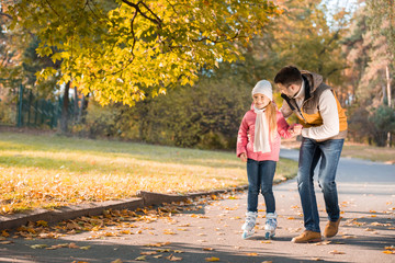 Father teaching daughter to roller skating