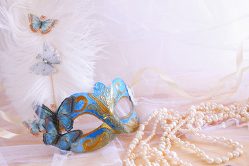 blue elegant venetian mask next to pearls