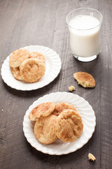 Two plates of Crumbled Snickerdoodle Cookies on a dark wooden background vertical shot
