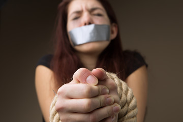 Brunette gagged and tied hands - obrazy, fototapety, plakaty