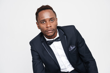 Young african businessman posing in studio and sitting