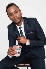 African young businessman drinking water while sitting.